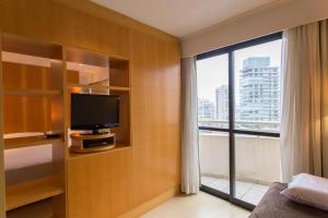 ein Hotelzimmer mit einem TV und einem großen Fenster in der Unterkunft (2708)Flat Ibirapuera Special (Apt particular) in São Paulo