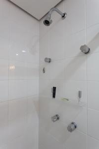 ein Bad mit einer Dusche und weißen Fliesen in der Unterkunft (2708)Flat Ibirapuera Special (Apt particular) in São Paulo