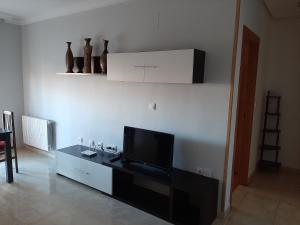 un salon avec une télévision à écran plat sur une table dans l'établissement Calle Quevedo, 27 Apartamento. Feria, à Albacete