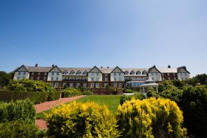 Una casa grande con un jardín enfrente. en Carden Park Hotel, Golf Resort and Spa, en Tilston