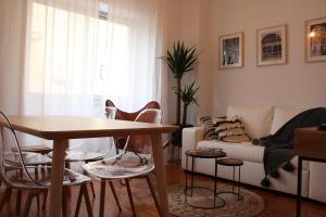 een woonkamer met een tafel en stoelen en een bank bij Bela Casa - Modern Designer Chic Central Coimbra in Coimbra