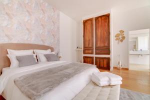 1 dormitorio con 1 cama blanca grande y pared de madera en Maison d'hôtes La Villa des Ducs Bar-le-Duc, en Bar-le-Duc