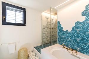 a white bathroom with a tub and a shower at Boutique Hotel Villa Gala in Cadaqués