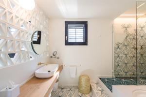 a bathroom with a tub and a sink and a mirror at Boutique Hotel Villa Gala in Cadaqués