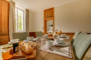 - une salle à manger avec une table et de la nourriture dans l'établissement Maison d'hôtes La Villa des Ducs Bar-le-Duc, à Bar-le-Duc