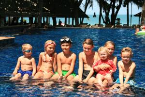 a group of children sitting in a swimming pool at Palita Lodge - SHA Plus in Haad Rin
