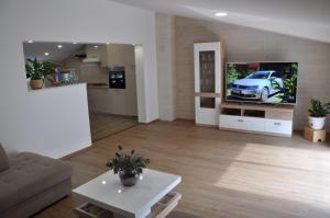a living room with a couch and a car on the tv at Apartman Đoni in Split