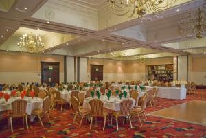 um salão de banquetes com mesas, cadeiras e lustres em Royal Court Hotel & Spa Coventry em Coventry