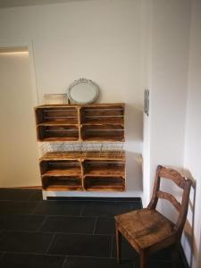 una silla sentada junto a una pared con estanterías de madera en Feriendorf Falkenegg, en Lennestadt