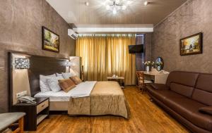 een hotelkamer met een bed en een bank bij Hotel Bravo Lux in Samara