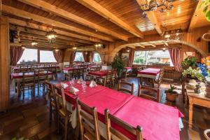 una sala da pranzo con tavoli e sedie rossi di Les Sorbiers a Montricher-le-Bochet