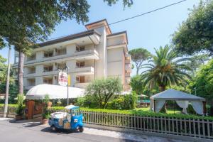 una vecchia auto blu parcheggiata di fronte a un edificio di Hotel Kyrton a Forte dei Marmi