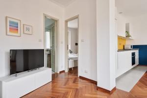 ein Wohnzimmer mit einem großen TV und einer Küche in der Unterkunft Urban House Carducci - Attic in Turin