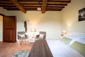 a bedroom with a large bed and two chairs at Castello di Gallano Resort in Valtopina
