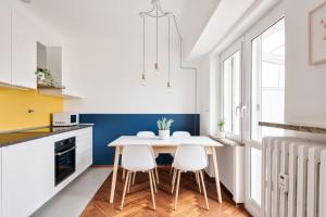 una cucina con tavolo bianco e 2 sedie di Urban House Carducci - Attic a Torino