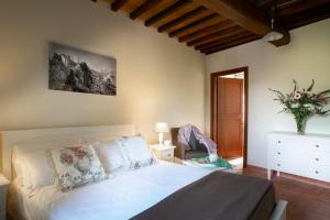 a bedroom with a white bed and a vase of flowers at Castello di Gallano Resort in Valtopina