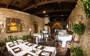 a restaurant with white tables and chairs in a room at Hotel Museo Spa Casa Santo Domingo in Antigua Guatemala