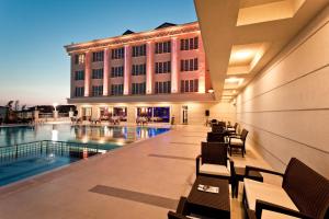 a hotel with a swimming pool in front of a building at Mercia Hotels & Resorts in Büyükçekmece