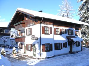 een gebouw met sneeuw op de grond ervoor bij Haus Rotspitze in Oberstdorf