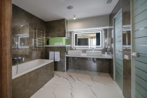 a bathroom with two sinks and a tub and a mirror at F&B Spa Resort (ex. Fomich Hotel) in Bukovel