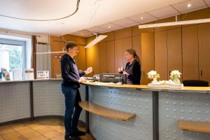 a man and a woman standing at a counter at Kiek in AöR Jugendherberge & Hostel in Neumünster