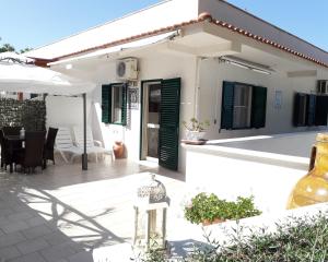 a white house with green doors and a patio at Residence Maresol in Vieste