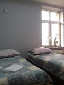 2 camas en una habitación con ventana en Willa Wygoda, en Białystok