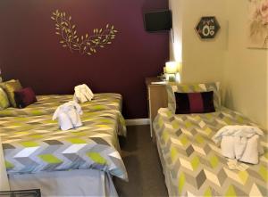 two beds in a room with towels on them at Haybow Farm Accommodation in Weston-super-Mare