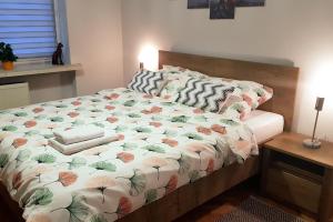 łóżko z kołdrą kwiatową w sypialni w obiekcie Apartament Nowowiejskiego w mieście Częstochowa