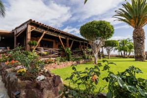 ein Resort mit Palmen und einem Gebäude in der Unterkunft Casa Tara in Alcalá