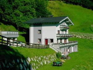 una gran casa blanca en una colina con una valla en Beim Untertimmeltaler, en Matrei in Osttirol