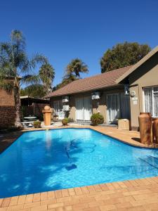 a swimming pool in front of a house at Memra Guest House in Ladysmith