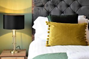 a bed with a yellow pillow and a lamp at Frederick Place - Your Apartment in Bristol