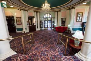 um quarto amplo com um lustre num edifício em The Grand Hotel em Llandudno