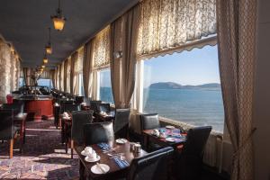 uma sala de jantar com vista para o oceano em The Grand Hotel em Llandudno