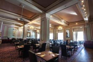 uma sala de jantar cheia de mesas e cadeiras em The Grand Hotel em Llandudno