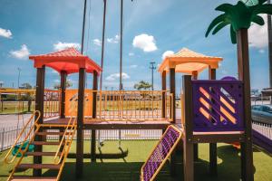 a playground with a slide and swings at Hotel 10 Itajai/Navegantes in Itajaí