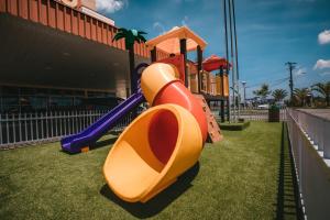 um escorrega num parque infantil em frente a um edifício em Hotel 10 Itajai/Navegantes em Itajaí