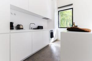 cocina blanca con armarios blancos y ventana en Avenida Premium by Homing en Lisboa