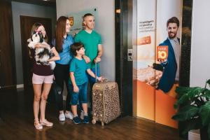 a family posing for a picture with a suitcase at Hotel 10 Itajai/Navegantes in Itajaí