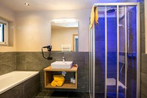 a bathroom with a sink and a shower at Alpinium - inklusive SUPER SOMMER CARD in Fiss