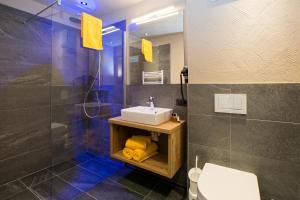 a bathroom with a sink and a shower at Alpinium - inklusive SUPER SOMMER CARD in Fiss