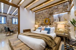 a bedroom with a large bed and a stone wall at Apartment Harmony in Dubrovnik