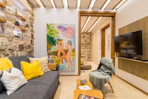 a living room with a gray couch and a tv at Apartment Harmony in Dubrovnik