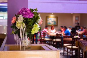 a vase of flowers on a counter in a restaurant at Hotel Tapachula in Tapachula