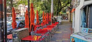 a row of red chairs and umbrellas on a sidewalk at Plaza España in Mendoza