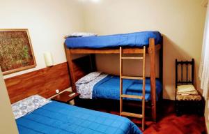 a room with two bunk beds with blue sheets at Plaza España in Mendoza
