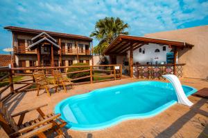 an outdoor swimming pool in front of a house at Pousada Muito Bonito in Bonito