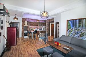a living room with a couch and a table and a kitchen at Top Center Relax, NDK & Vitosha str, FREE Secured parking in Sofia