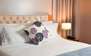 a bedroom with a bed with two pillows on it at Hotel Prado Real in Barranquilla